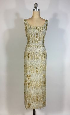 "It is an honor and a pleasure to be listing this breath-taking, fabulous, rare, Samuel Winston by Roxane gown! This late 1950's gown (so, slightly post-Charles James designs for the company) is truly a spectacular, museum-quality gem. The ivory colored crepe silk base of this dress is layered over in a silk chiffon that's heavily hand-beaded, with glass bugle beads, in squiggling bands of alternating silver and gold. These gold bands feature gold seed beads fringe loop droplets, seed bead leaves, flower buds with aurora borealis bead centers and oblong metallic gold bead petals. The overall beading on this dress was excellent when found. I have replaced two small areas of missing beading and secured any loose spots. Back of dress has low-cut scoop and metal zipper closure at center back, Vintage Gold Evening Dress For Gala, Vintage Gala Gown With Fitted Bodice, Vintage Gown With Fitted Bodice For Gala, Vintage Floor-length Evening Dress For Vintage Events, Vintage Gold Evening Dress For Wedding, Vintage Fitted Gown For Gala, Fitted Vintage Gown For Gala, Vintage Floor-length Gown For Gala, Vintage Floor-length Gala Gown