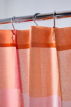 an orange and pink curtain hanging from a metal rod