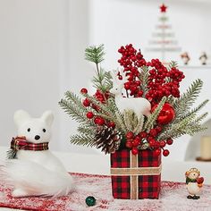 a white bear sitting on top of a table next to a christmas present