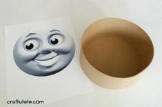 a paper cup with a face drawn on it next to a cardboard bowl that has been cut out into the shape of a smiley face