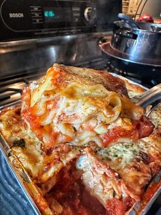 a pan filled with lasagna casserole sitting on top of a stove