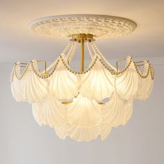 a chandelier hanging from the ceiling in a room with white walls and flooring