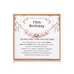 the 70th birthday card with pearls and flowers on it is displayed in a wooden frame