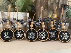 christmas ornaments with snowflakes on them are displayed in front of a wooden sign