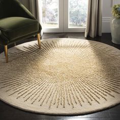 a round rug in the middle of a room with a green chair and window behind it