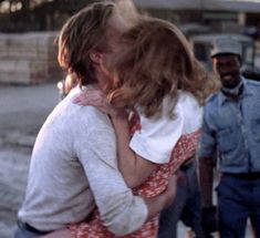 a man and woman embracing each other in the street