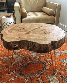 a wooden table sitting on top of a rug in front of a leather chair and couch