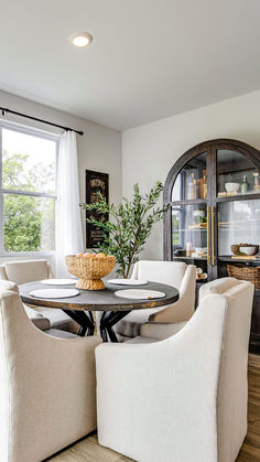 the dining room table is surrounded by white chairs