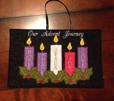 a sign with three candles on it that says our advert journey hope, love, and joy