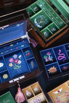 an assortment of jewelry boxes with designs on the inside and outside, including brooches