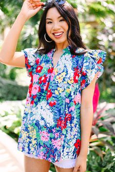 This colorful floral blouse is sure to make you stand out from the crowd! With its vibrant color palette and smocked detailing, this blouse is the perfect way to express your unique style and let your personality shine. This blouse features short sleeves, ruffle detailing, a split v-neck, and a vibrant floral print.  Material has no amount of stretch.Cindy is wearing the small. Spring Floral Print Blouse With Butterfly Sleeves, Multicolor Butterfly Sleeve Tops With Ruffles, Summer Floral Print Blouse With Butterfly Sleeves, Summer Butterfly Sleeve Blouse With Floral Print, Stretch Floral Print V-neck Blouse, Multicolor Flutter Sleeve Top For Brunch, Vacation Blouse With Butterfly Sleeves And Floral Print, Multicolor Printed Blouse With Ruffle Sleeves, Butterfly Sleeve Blouse With Floral Print For Vacation