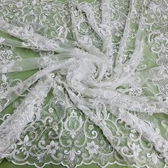 Discover exquisite elegance with the exquisite Beaded & Sequined Lace Fabric Embroidered on 100% Polyester Net Mesh from Lace USA! Our luxury lace fabric features gorgeous hand-beaded and sequined detailing, perfect for couture lace, bridal lace, evening dress lace, Quinceanera dress lace, dance costume lace, and so much more. This sumptuous fabric is perfect for any special occasion, from weddings to formal dances and everything in between. The embroidered lace is available in two stunning colo Elegant Fitted White Embroidered Fabric, Elegant Embroidered White Lace, Elegant Lace Fabric With Resham Embroidery, Elegant White Lace With Floral Embroidery, Elegant White Lace With Pearl Embroidery, Elegant Off-white Fabric With Floral Embroidery, White Lace Embroidered Fabric, Elegant Off-white Embroidered Fabric With Floral Design, Elegant White Sequin Fabric With Delicate Lace