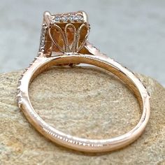 a close up view of an engagement ring on top of a rock