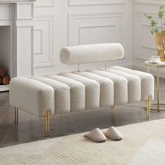 a white bench sitting in front of a fire place next to a rug on the floor