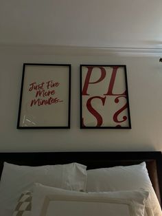 two framed pictures on the wall above a bed