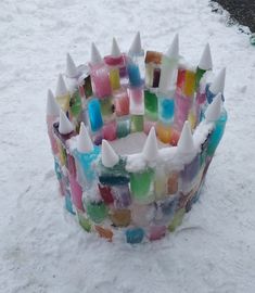 a colorful glass bowl sitting in the snow with white spikes on it's sides