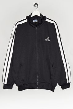 "Vintage 90's 00's Adidas track jacket in black with three stripes in white. - Size tag: Please always check measurements before buying. Men's L - Measurements (laying flat): Pit to Pit: 25.5\" Length: 28.5\" Sleeve: 23\" Pit to Cuff: 20.5\" Across the shoulders: 23.5\" -Wear: /Please see images for details/ Good used condition. Small rip on the sleeve as shown on the picture. - Fabric: Polyester *All of our items are preloved pieces so some signs of natural wear and age are to be expected. Plea Adidas 90s Coat, Classic Winter Track Jacket For Streetwear, Sportswear Outerwear With Contrast Stripes For Streetwear, Casual Track Jacket With Contrast Stripes For Streetwear, Winter Track Jacket With Contrast Stripes And Long Sleeves, White Track Jacket With Contrast Stripes For Winter, Black Track Jacket With Side Stripes For Streetwear, White Winter Track Jacket With Contrast Stripes, Contrast Stripes Outerwear For Streetwear