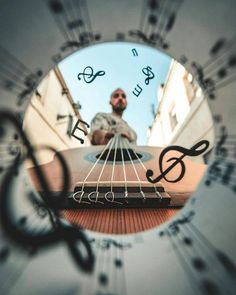 the reflection of a man playing an acoustic guitar