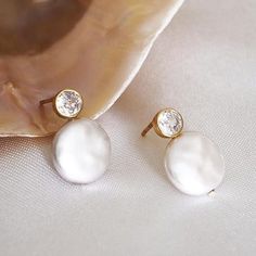 HIGH-LUSTER WHITE FRESHWATER BUTTON PEARL EARRINGS FOR WOMEN - THE AAA QUALITY, GIA-CERTIFIED GENUINE STUD PEARL EARRINGS YOU CAN TRUST! ------------------------------------------------------- Pearls have always been a symbol of natural feminine beauty and power. Conveying unmatched craftsmanship and timeless elegance. These unique freshwater button pearl earrings are the ideal statement piece for your jewelry collection. Offering timeless elegance, and perfect for all occasions. These earrings will become your go-to accessory and are the perfect gift for your loved ones. * Metal: 925 Sterling Silver * Finish: 18k Gold  * Pearl: Natural Freshwater Button Pearl * Gemstone: 5A Grade Round Brilliant Cut Cubic Zirconia, GIA Cutting Standard  * Size: 14-15mm HANDMADE WITH LOVE 🤍 All of our pea White Dainty Bridal Earrings For Formal Occasions, Formal White Dainty Bridal Earrings, Delicate White Crystal Earrings For Party, White Dainty Pearl Earrings, Dainty White Pearl Earrings For Anniversary, Elegant White Crystal Earrings For Gift, White Round Earrings For Bridesmaids, Delicate White Pearl Earrings For Anniversary, White Dainty Round Bridal Earrings