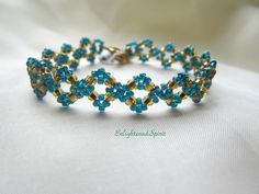 How cute is this bracelet?? It`s simple but eye catching with it`s intricate pattern. Great match to all your holiday outfits. Made with gold and gorgeous rainbow teal seed beads and very strong beading material.  Fits about 6.5 ìn and the toggle clasp ensures it will stay securely on your wrist.  This item is already made and ready to ship. ஐ ¸.**'¯) ஐ ¸.**'¯) ஐ ♥ All items handmade in beautiful Nova Scotia, Canada ♥ ** To check out other handmade designs in my shop: http://www.etsy.com/shop/EnlightenedSpirit ** Payment & shipping policy:  http://www.etsy.com/shop/EnlightenedSpirit/policy ** Questions? Don't hesitate to convo me! http://www.etsy.com/conversations/new?with_id=5081355 ஐ Thank you for choosing Handmade! Elegant Handmade Bracelets As Bridesmaid Gift, Elegant Handmade Bracelets For Bridesmaids, Elegant Handmade Light Blue Beaded Bracelets, Blue Gold Beaded Bracelet, Blue Gold Beads Bracelet, Light Blue Bracelet For Party, Elegant Handmade Turquoise Beaded Bracelets, Handmade Gold Beaded Bracelets For Formal Occasions, Handmade Adjustable Beaded Bracelets For Formal Occasions