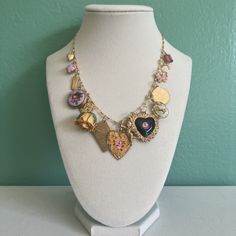 Houston Charm Necklace. Made with curated vintage charms including enamel heart, enamel locket, vintage brass, glass, etc. Newer enamel butterfly and real resin rose charm. 14k gold filled chain and jump rings.