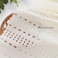 a basket filled with flowers sitting on top of a white table covered in lacy doily