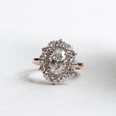 an oval shaped diamond ring on a white surface