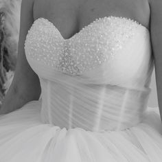 black and white photograph of a woman in a wedding dress with pearls on the bust