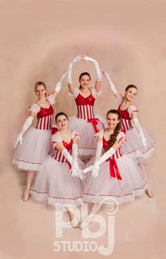 four girls in red and white dresses are posing for the camera