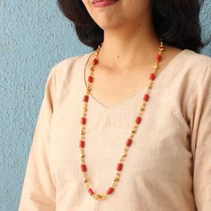 A typical coral-colored South Indian Laxmi pendant design featuring coral beads and gold-polished beads and chain with a high gold polish. A beautiful selection for all occasions, handmade with perfection. Match this jewelry with any of your outfits and flaunt your style. Length - 28 inches. Festive Red Pearl Chain Jewelry, Festive Beaded Necklace, Orange Polished Beads Necklaces For Festive Occasions, Gold Temple Jewelry Beads With Dangling Details, Gold Beaded Necklaces With Red Coral Round Beads, Gold Beaded Necklace With Polished Red Coral, Gold Necklace With Polished Red Coral Beads, Red Gold Plated Temple Jewelry Necklaces, Red Coral Necklace With Gold Beads For Gift