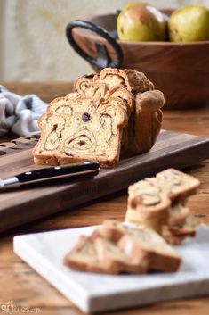 sliced loaf of bread sitting on top of a cutting board next to some apples and a knife