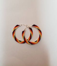 two pairs of hoop earrings on a white surface