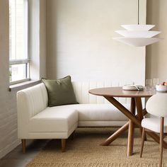 a living room with a couch, table and chair next to a large white lamp