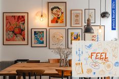 a dining room table with chairs and pictures on the wall above it that says feel