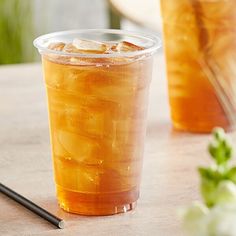 two drinks are sitting on a table next to some chopsticks and an orange drink