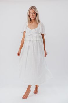 The Madeline Midi Dress is a breath of fresh air -- its feminine coastal vibe and creamy off-white hue is the perfect choice for special occasions or everyday wear. We particularly love its relaxed waist and ruffle details. Pair with slides or heels for an elegant, comfortable style any day of the week. FIT: Runs true to size. MATERIAL: 100% Cotton. GARMENT DETAILS: Lightweight cotton midi dress with a sweetheart neckline, loose short sleeves, and ruffle accents, with a low scooped back and tie detail. Finished with a 3-button detail at the empire-waisted bodice. SIZE GUIDE: XS (0-2) / S (2-4) / M (6-8) / L (10-12) / XL (14-16) MODEL DETAILS: MISSES Mackenzie - Size S Heather - Size S Bust 34" 34" Waist 27.5" 27.5" Hips 40.5" 37.5" Height 5'7" 5'7" Garment Details, A Breath Of Fresh Air, Comfortable Style, Cotton Midi Dress, Breath Of Fresh Air, Day Of The Week, Loose Shorts, Comfortable Fashion, Button Detail