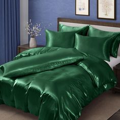 a green comforter set on a bed in a room with blue walls and curtains