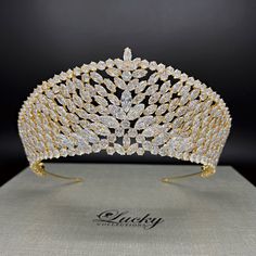 A breathtaking tiara designed in line with elegant royal crowns. Hundreds of perfectly cut high-quality Cubic Zirconia enhance the curvature of this piece. A single solitaire marquise zirconia completes the upper slanted row.  Available on www.ProBridalUSA.com *Handcrafted with highest quality Zirconia jewels and rhodium plated to prevent tarnish and scratch. *High Quality Teardrop, Marquise and Round CZ gems. *Measures 2.875 inches in center  *Ideal for Wedding, Bridal Hair, Anniversary, Quince Regal Structured Crown Wedding Headpiece, Regal Wedding Headpiece With Structured Crown, Regal Structured Crown Headpiece For Wedding, Elegant Gold Wedding Crown, Gold Round Crown Headpiece For Weddings, Gold Wedding Headpiece With Round Crown, White Wedding Crown With Pinched Shape, Regal Gold Headpiece For Wedding, Regal Gold Headpieces For Weddings