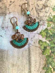 "Beautiful, hand-crafted embossed copper earrings with an oxidized patina in shades of green, blue and copper.  Swirled, hammered copper wire, aqua blue chalcedony gemstone beads & copper beads, along with my hand-made copper ear wires, complete the design.    Overall earring length is 2.5\". These Bobo beauties are really cool, lightweight, and so much fun to wear." Blue Artisan Copper Earrings, Artisan Blue Copper Earrings, Soldered Turquoise Brass Earrings, Turquoise Soldered Brass Earrings, Artisan Turquoise Earrings In Copper, Artisan Turquoise Copper Earrings, Bohemian Jewelry In Copper Wire With Patina, Turquoise Artisan Electroformed Earrings, Vintage Copper Earrings With Patina