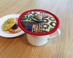 there is a cup with some cookies in it and a plate on the table next to it