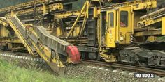 an old train is sitting on the tracks near some grass and trees in the background