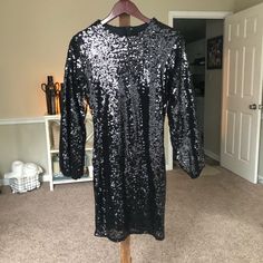 Woman’s Black Sequin Dress Size Medium. Never Worn And In Excellent Condition. The Dress Has Long Sleeves And Zips Up The Back Black Long Sleeve Sequin Dress For Date Night, Black Long Sleeve Sequin Dress For Holiday Party, Black Long Sleeve Sequin Dress For Spring, Black Sequin Dress For Holiday Party In Fall, Black Knee-length Sequin Dress For Night Out, Black Sequin Dress, Dress Medium, Black Sequins, Sequin Dress