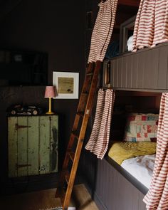 a bunk bed with pink and white striped curtains hanging from it's top rail