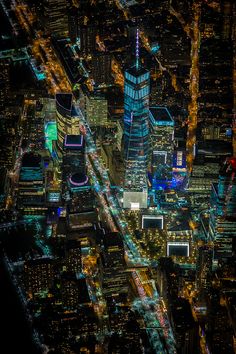 an aerial view of the city at night with lights and skyscrapers in the background