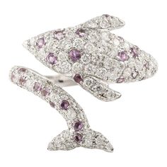 This is part of Chairish’s Fine Jewelry assortment.  Amethyst and Diamond Dolphin Ring in 18K Gold featuring natural amethyst of 0.35 carats and diamond of 1.13 carats. The gorgeous handcrafted ring goes with every style, every occasion or any outfit.  Amethyst encourages self-control and strengthens the bond in a relationship. Designed with round cut diamond studded all over the dolphin with amethyst in between the diamonds making a open ring of dolphin face on one side with tail on another tha Exquisite Purple Diamond Rings, Fine Jewelry Amethyst Ring With Diamonds, Amethyst Diamond Ring With Diamond Accents In White Gold, White Gold Amethyst Diamond Ring With Accents, Purple Diamond Gemstone Ring, Purple Multi-stone Diamond Ring, Fine Jewelry Amethyst Diamond Ring With Accents, Purple Diamond Ring With Gemstone, Amethyst Diamond Ring With Accents In Fine Jewelry Style