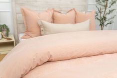 a bed with pink sheets and pillows on it