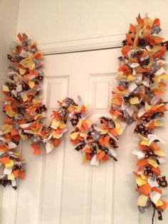 two wreaths made out of orange and white paper on the front door with black polka dots