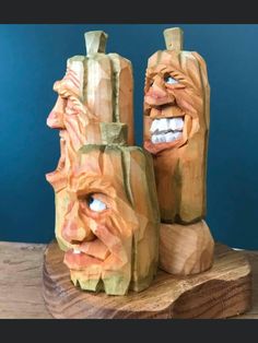 two carved wooden faces are sitting on a table