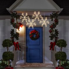 a blue door decorated with christmas wreaths and lights