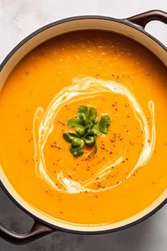 a bowl filled with soup and garnish on top of a white countertop